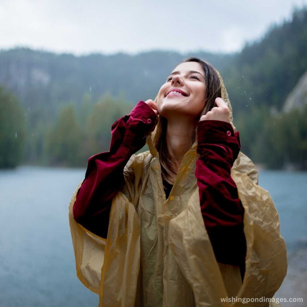 A happy woman in raincoat near the lake - Nature Images