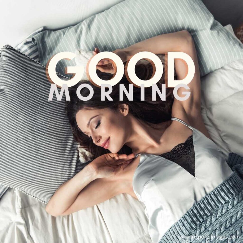 A young girl stretches in bed in the morning