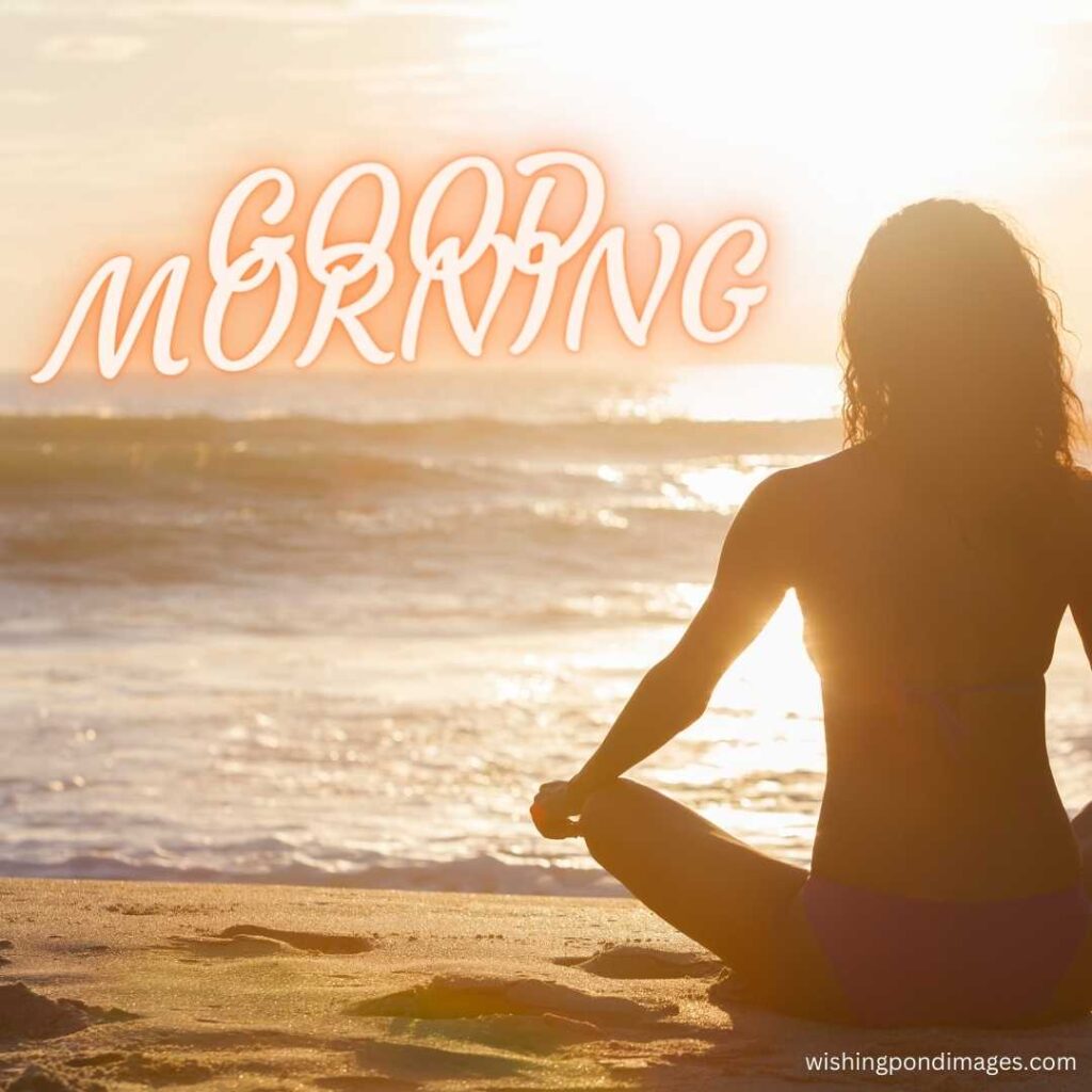 A young girl wearing a bikini costume sitting in meditating pose at the beach in the morning