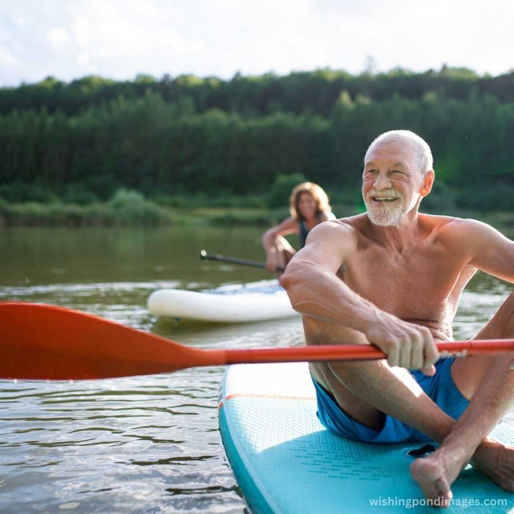 A senior couple paddleboarding in the lake - Nature Images