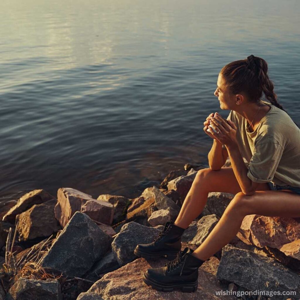 Girl sitting on the small rocks near the lake - Nature Images
