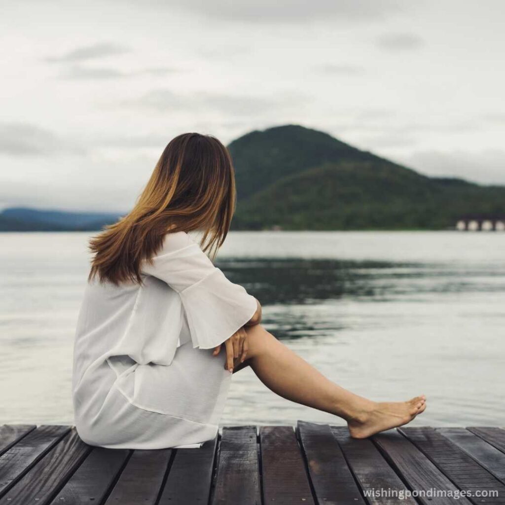 Woman relaxing on a wooden pier near the lake - Nature Images