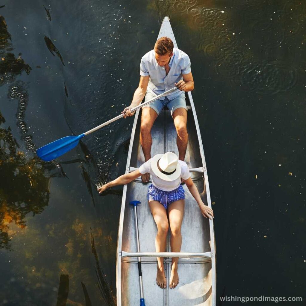 Young couple paddling their boat in the lake - Nature Images