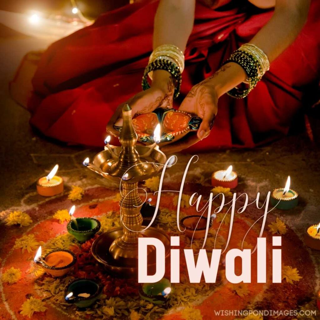 
A woman decorating house with diyas - Happy Diwali Image