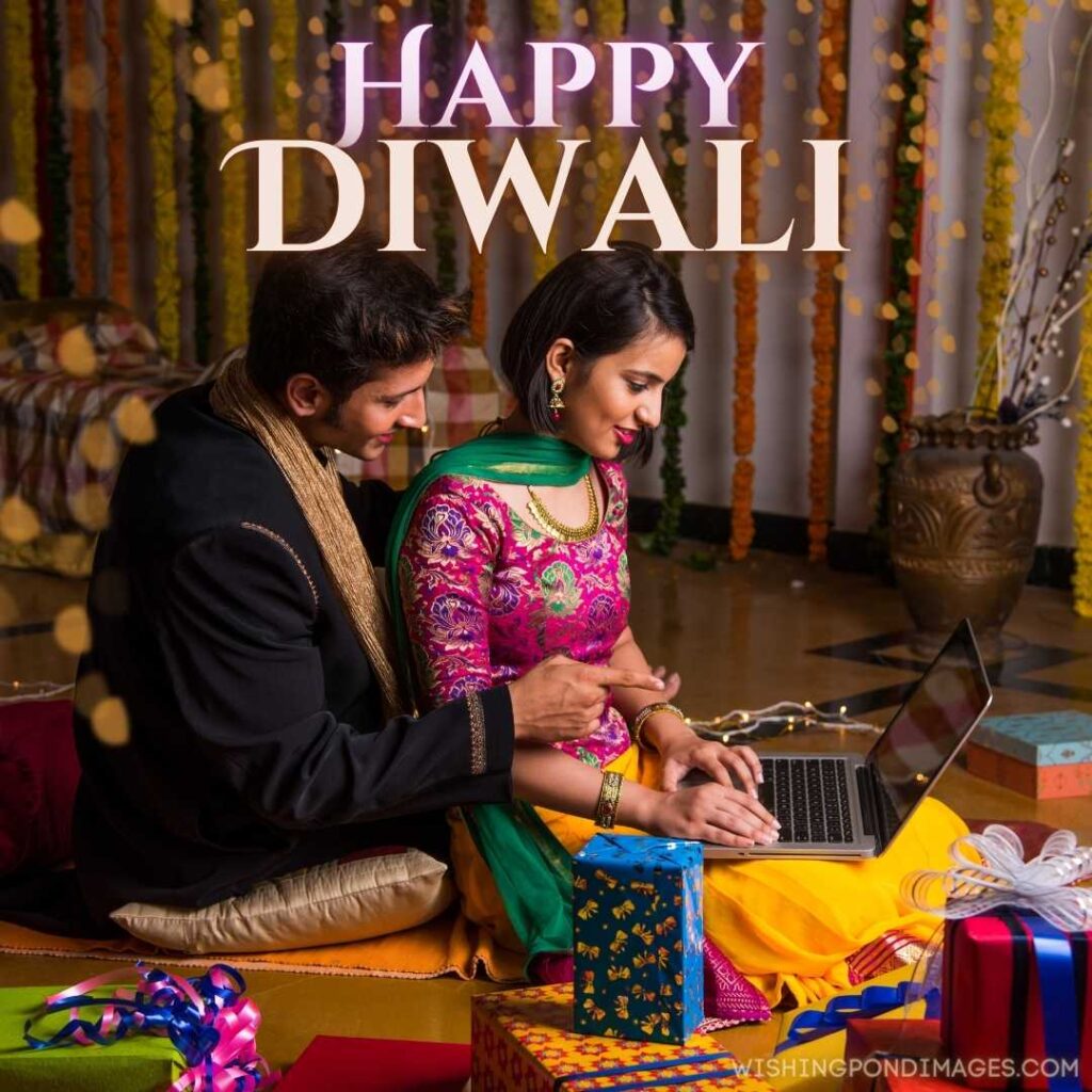 A young Indian couple sitting and wishing Happy Diwali on a laptop - Happy Diwali Images