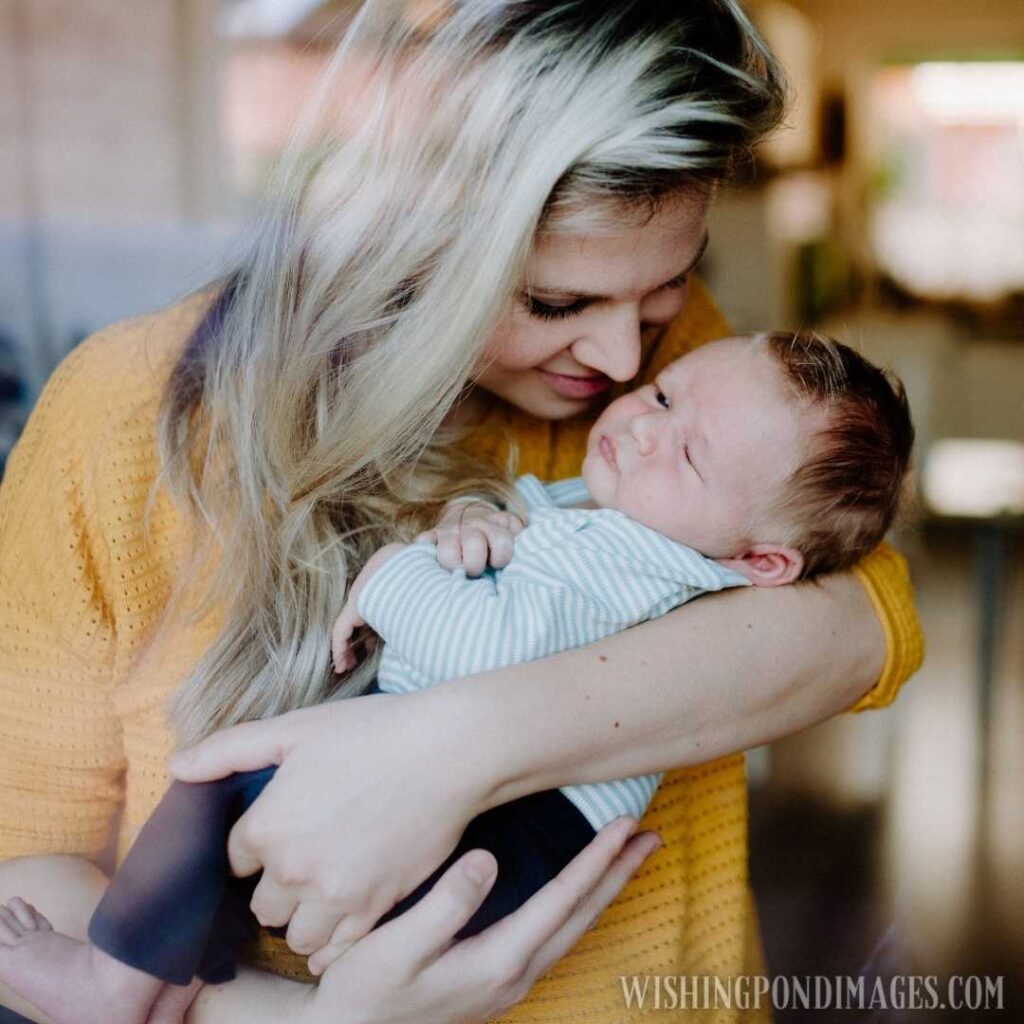 A beautiful young mother holding a newborn baby at home. Newborn baby image