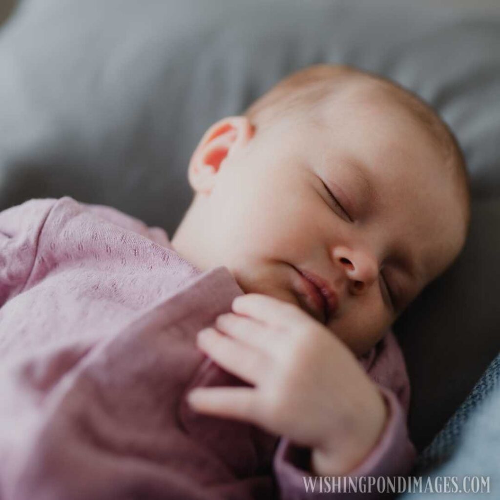 A portrait of a newborn baby girl, sleeping and lying on sofa indoors at home. Newborn baby image