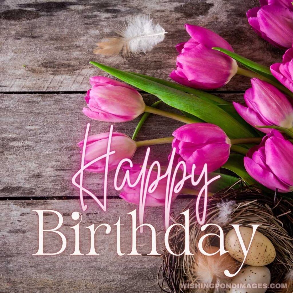 Bouquet of purple tulips with a nest with eggs on a wooden background - Happy Birthday Flower Images