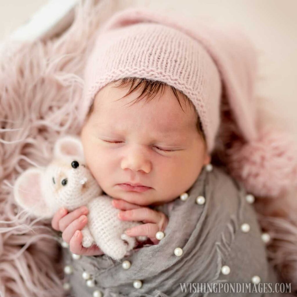 Cute newborn with toy in tiny hands. Newborn baby images