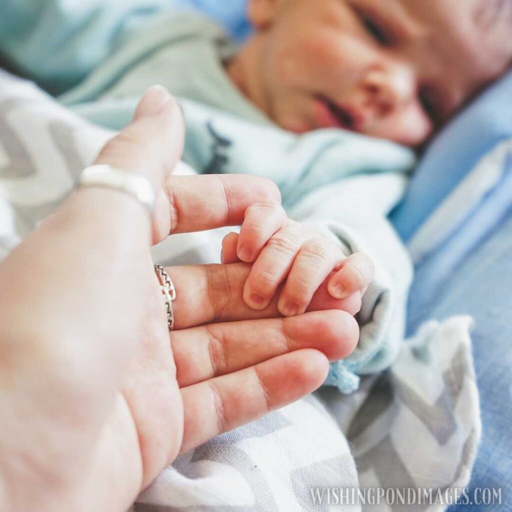 Little hand of a newborn baby holding finger of mum. Newborn baby image