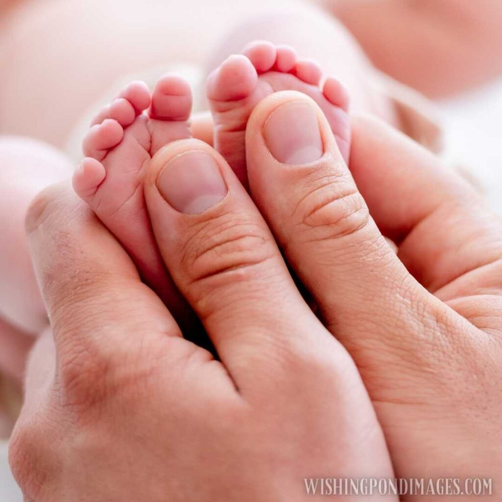 Mother holding tiny newborn baby feet with little fingers closeup. Newborn baby images
