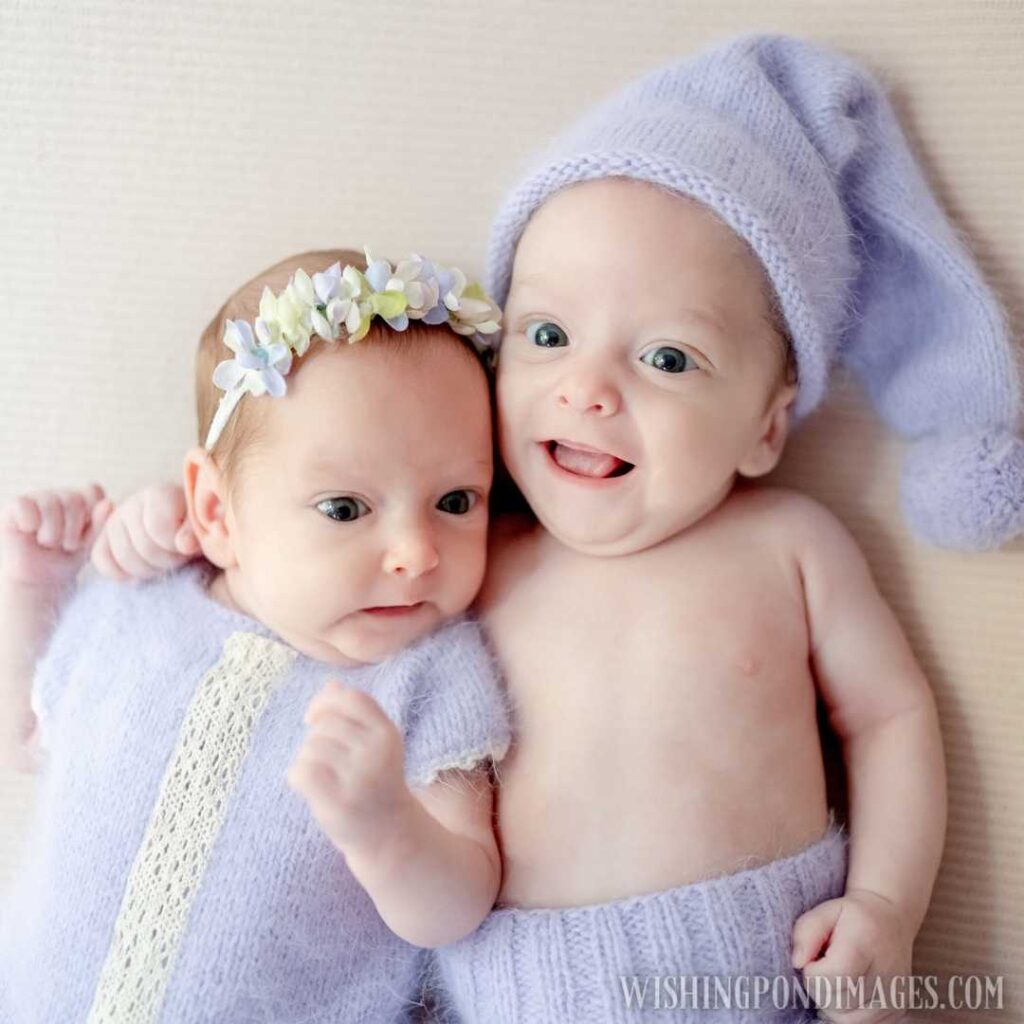 Newborn babies twins wearing knitted costumes lying together and looking at camera. Newborn baby images