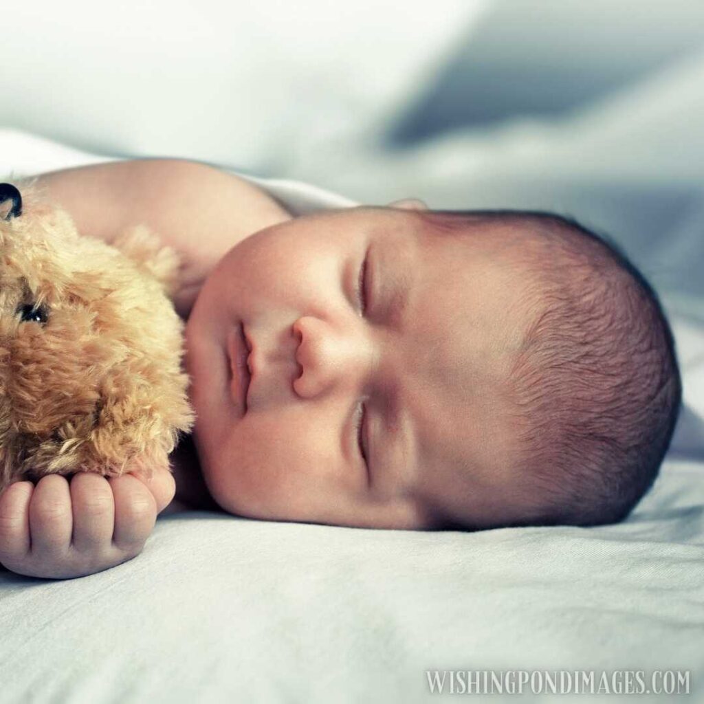 Newborn little cute baby lying on bed with toy at home. Newborn baby images