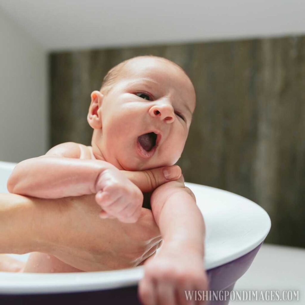 Newborn yawning in the bath tub. Newborn baby images