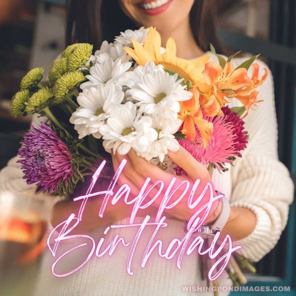 Partial view of smiling young woman holding colorful bouquet from various flowers in cafe