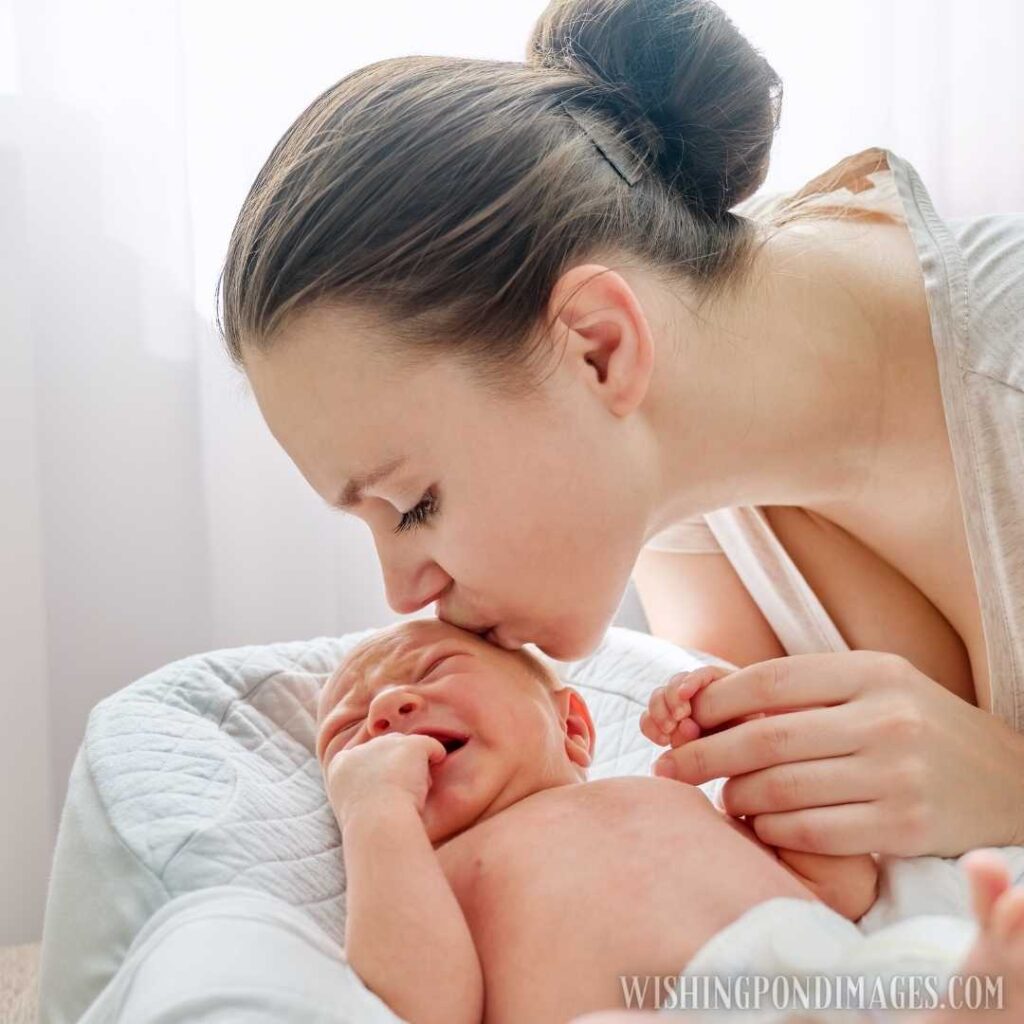 Young mother kissing crying newborn baby son. Newborn baby images