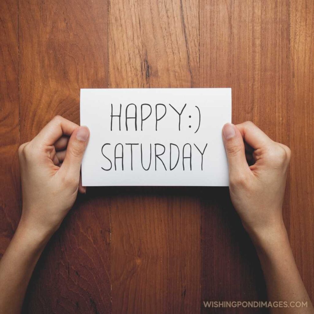 A woman with a sign in her hands with the words happy saturday - Good morning happy saturday