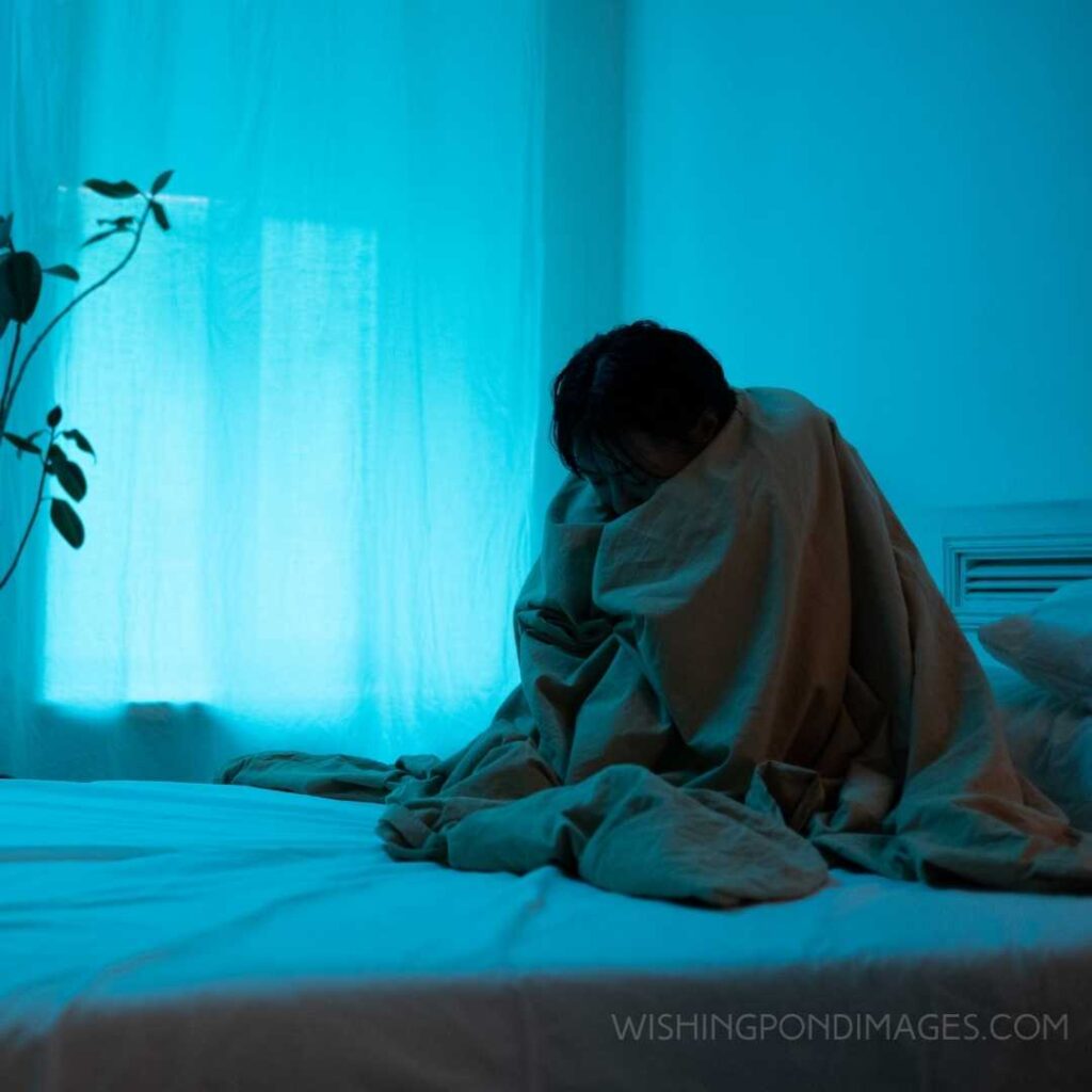 A lonely woman sitting on the bed. Feeling alone images girl.