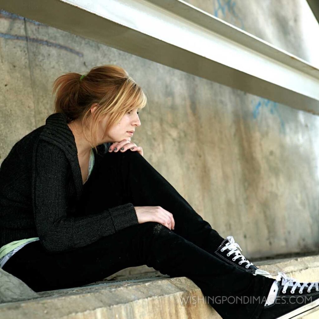 A teen girl sits alone under a bridge. Feeling alone images girl.