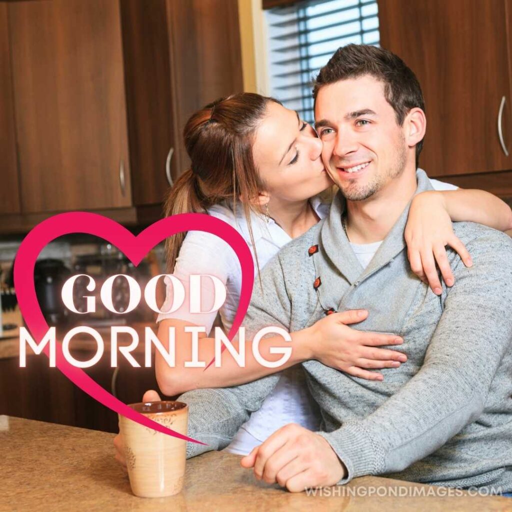 A young beautiful girl kissing her boyfriend in the kitchen while drinking coffee. Good Morning Coffee Images