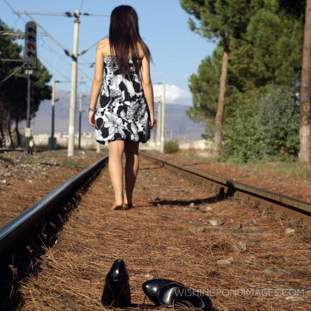 A young girl walking alone on the rail track. Feeling alone images girl.