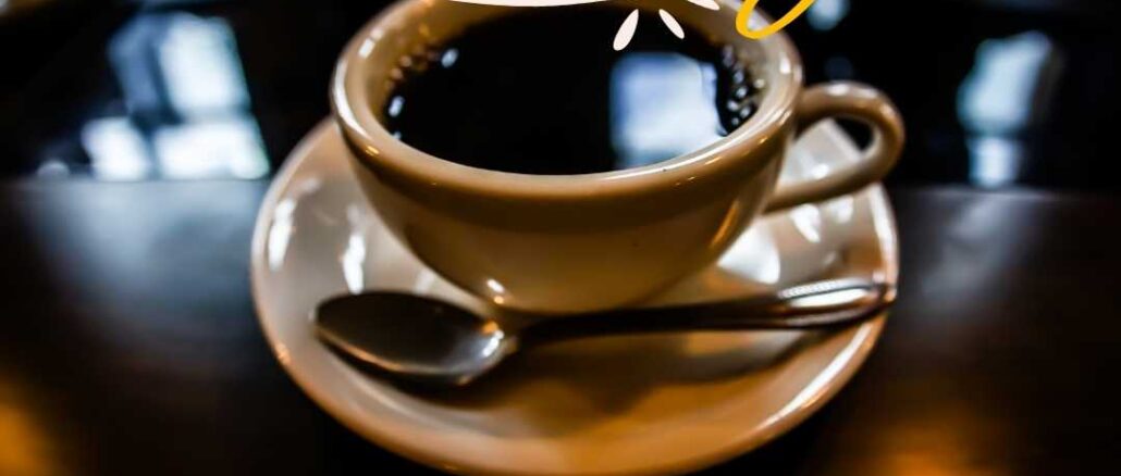 Black coffee image on a plate with a spoon on the dark brown-colored table. Good Morning Coffee Images