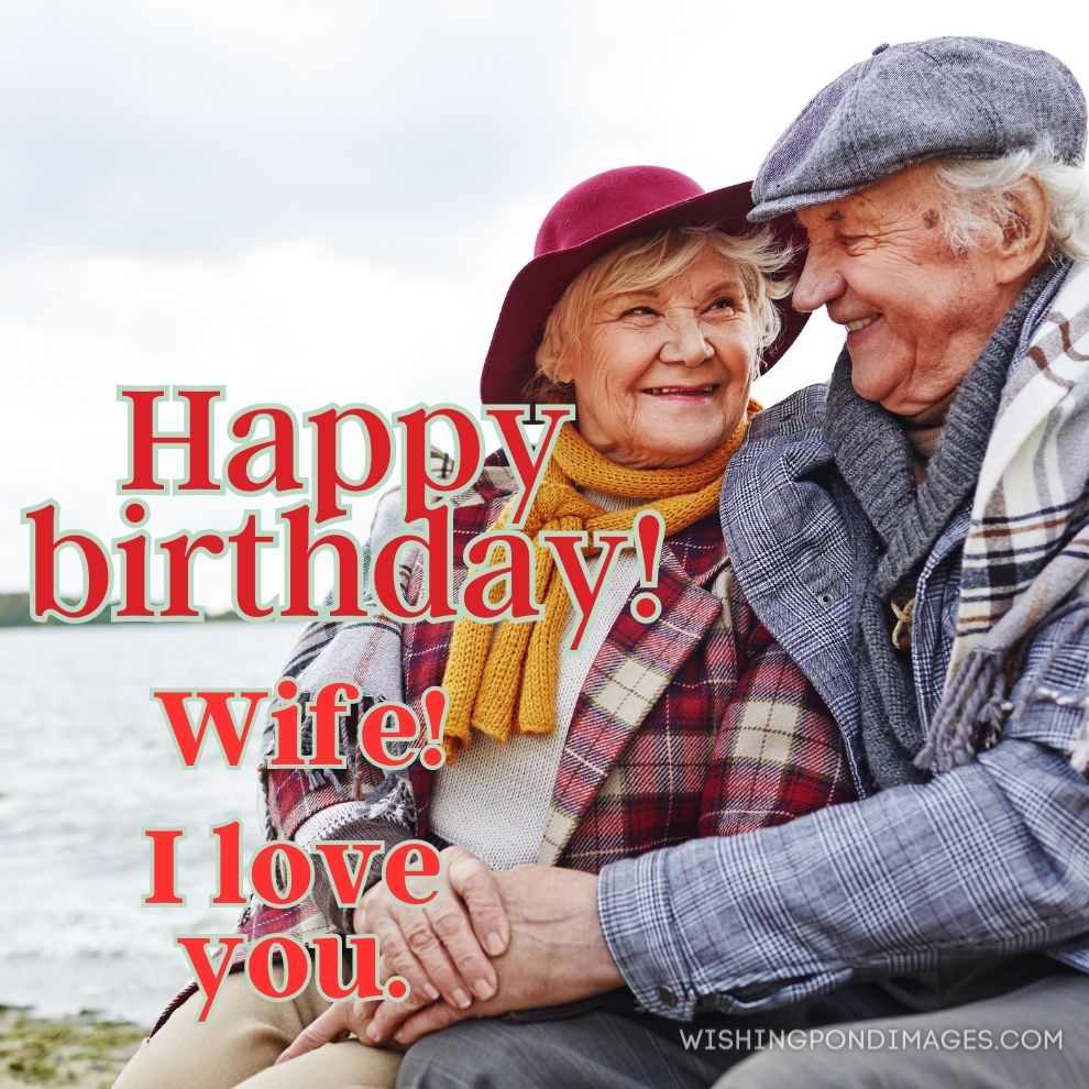 Cheerful and affectionate seniors sitting by seaside in autumn. Happy birthday wife images.