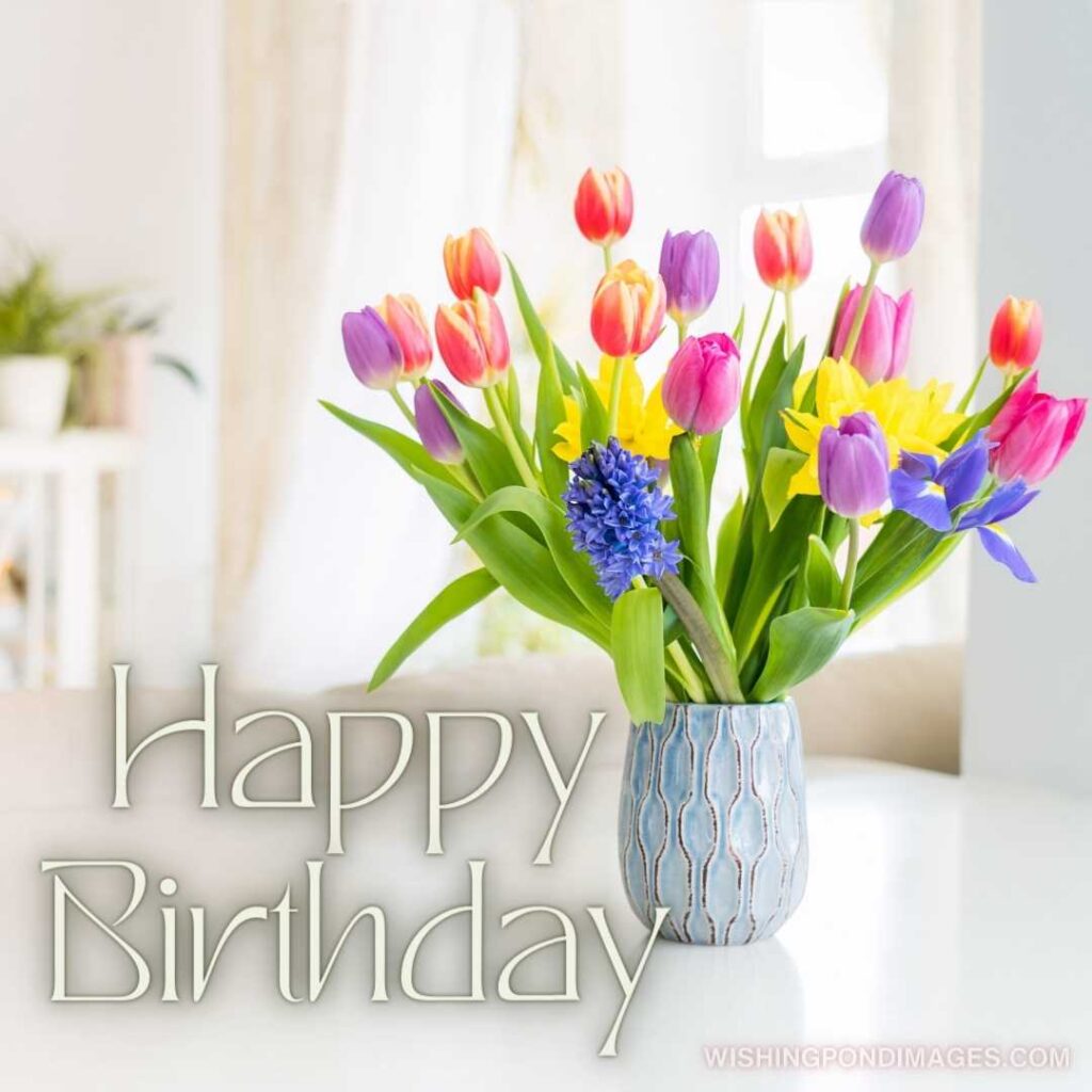 Fresh spring colorful bouquet of tulips flowers in vase standing on white marble table. Happy birthday tulips flowers images