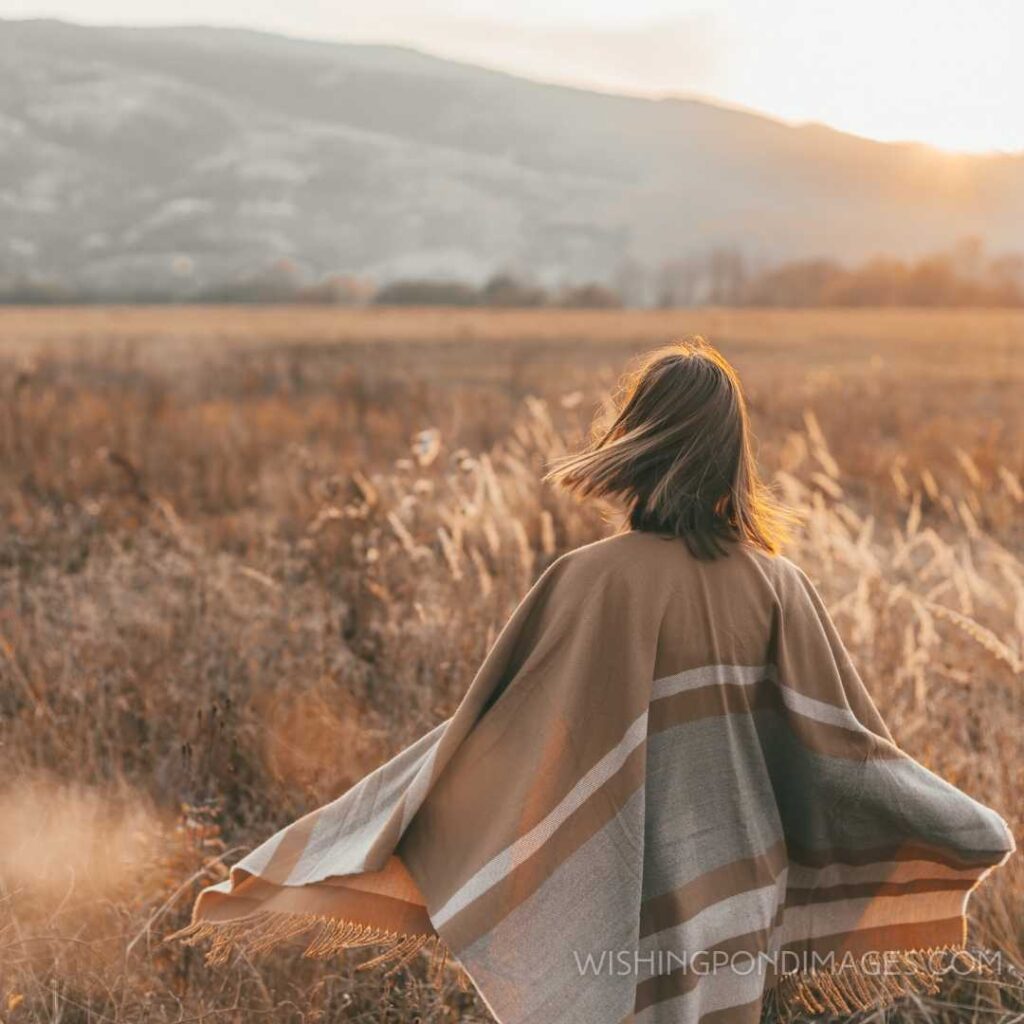 The girl in the poncho travels alone in a field with a view of sunlight. Feeling alone images girl.