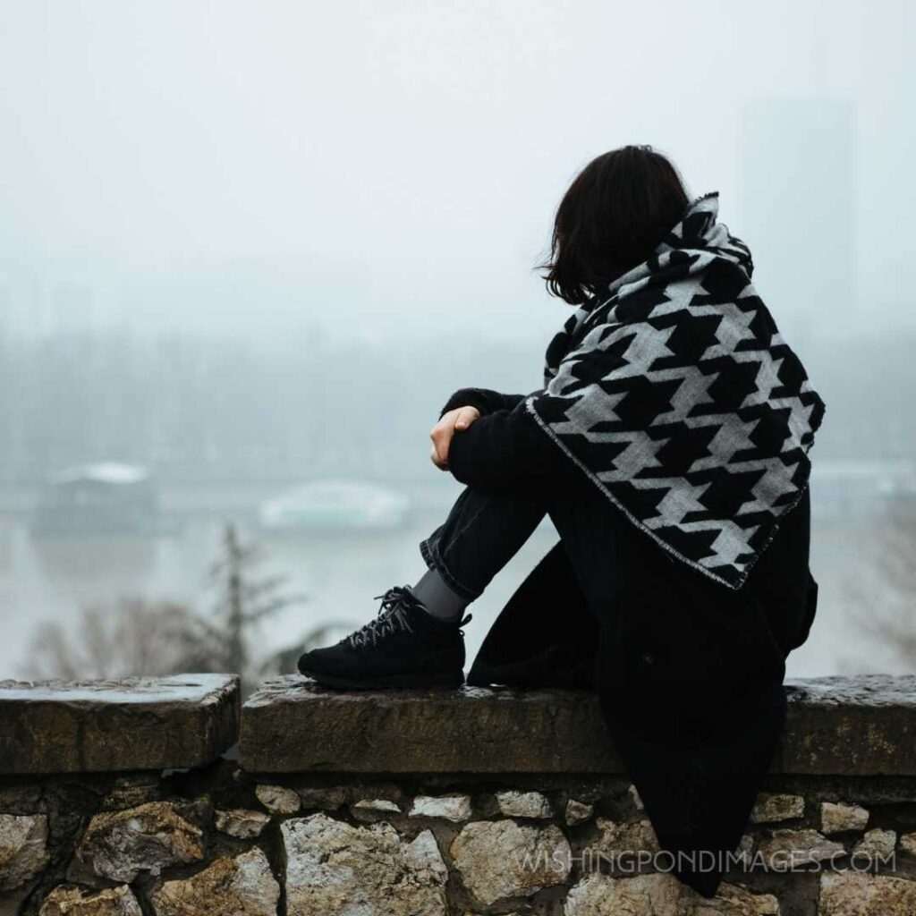 A girl sitting on a wall and having a tough time. Feeling alone images girl.