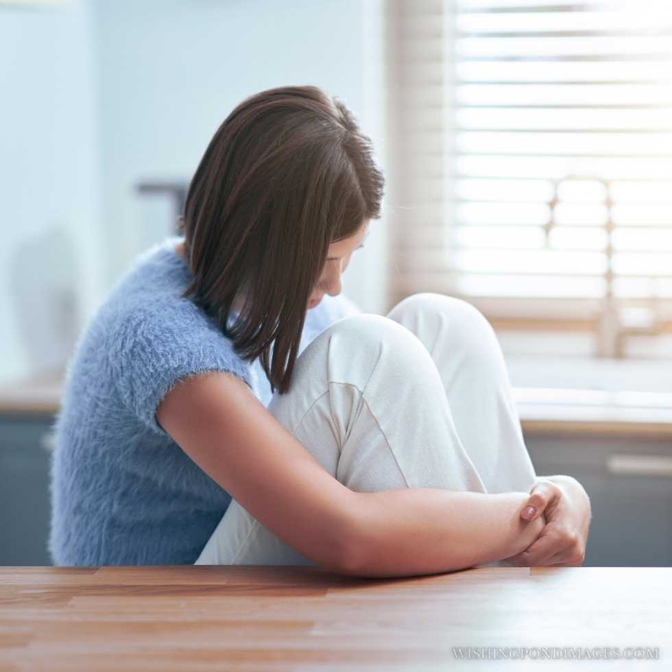 Picture of a sad teenager sitting alone at home. Sad girl in room.