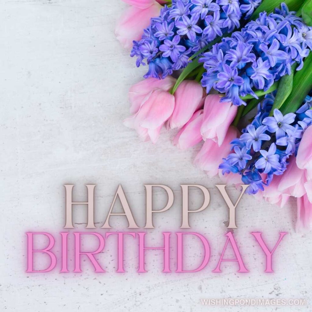 Pink tulips and blue hyacinths flowers on white wooden table. Happy birthday tulips flowers images