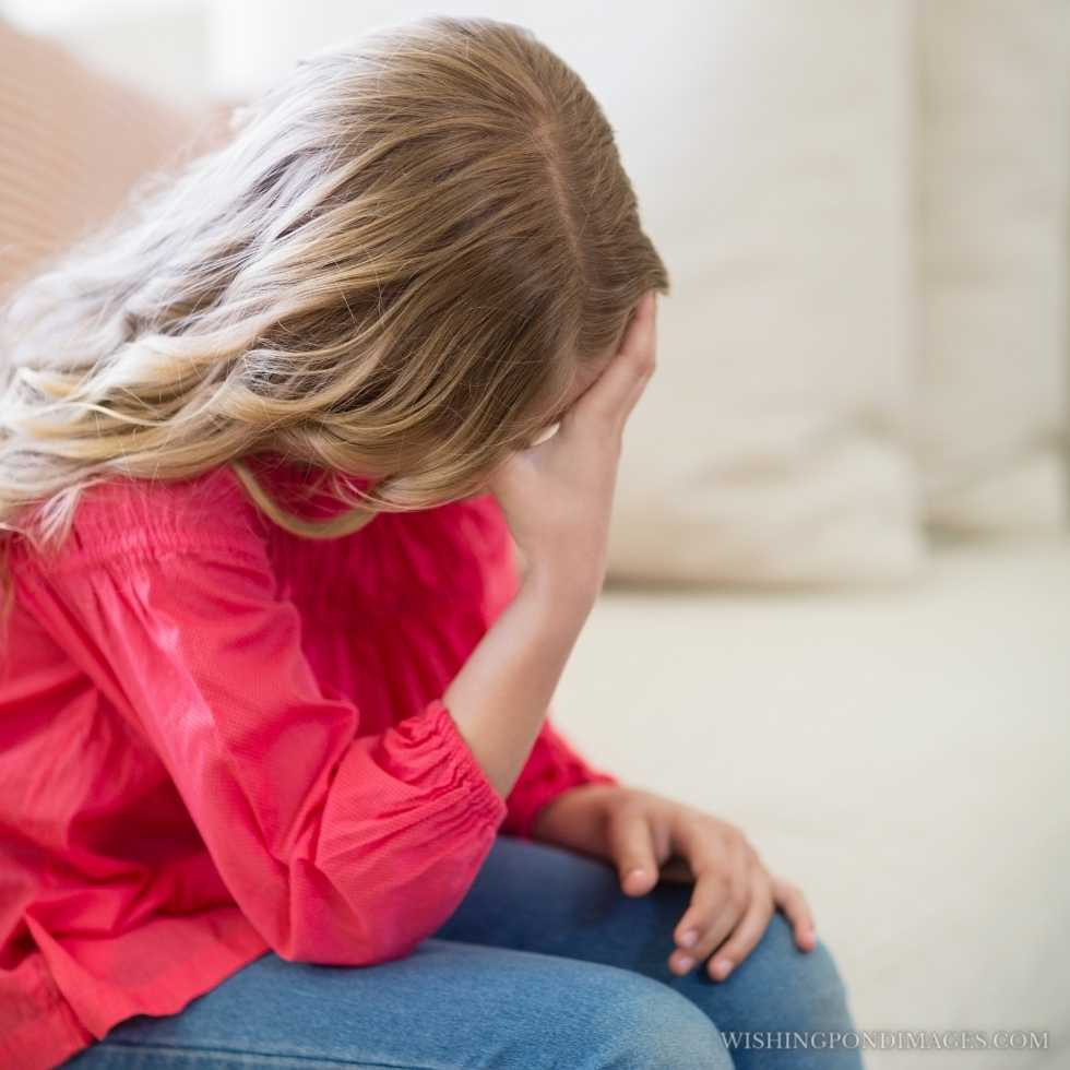 Sad girl sitting on the sofa in the living room at home. Sad girl in room.