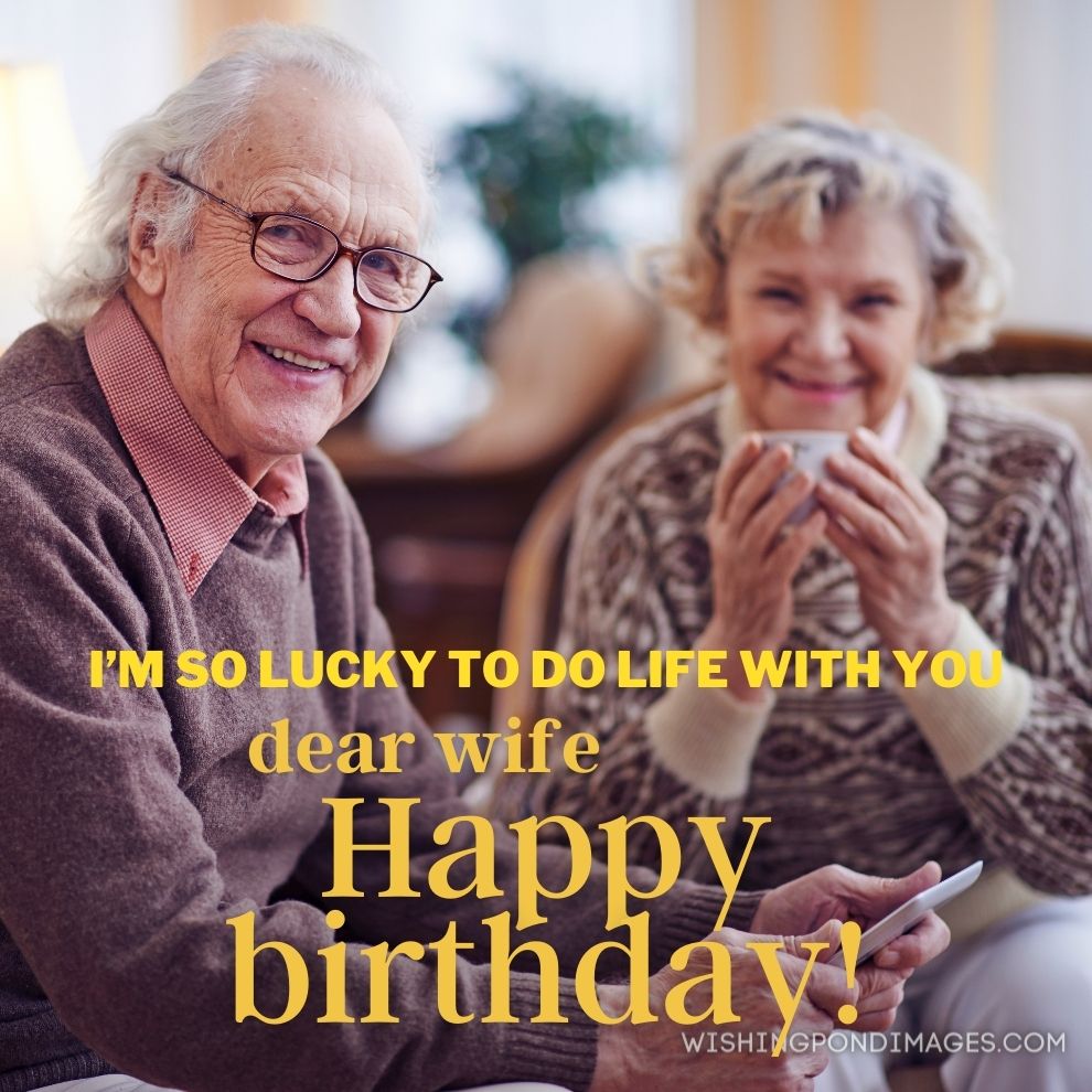 Senior man with touchpad looking at camera with his wife sitting on background. Happy birthday wife images.