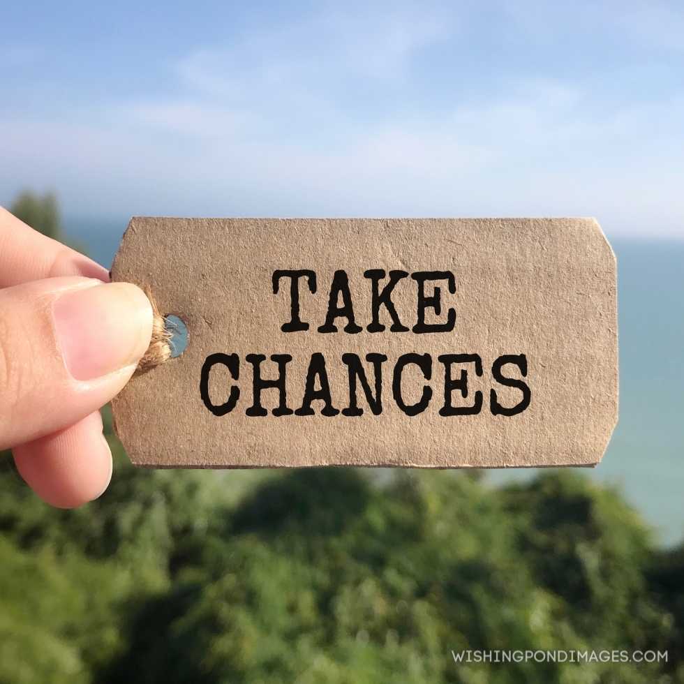 Take Chances_ written on a paper tag. Blurred styled background. Inspirational quotes images