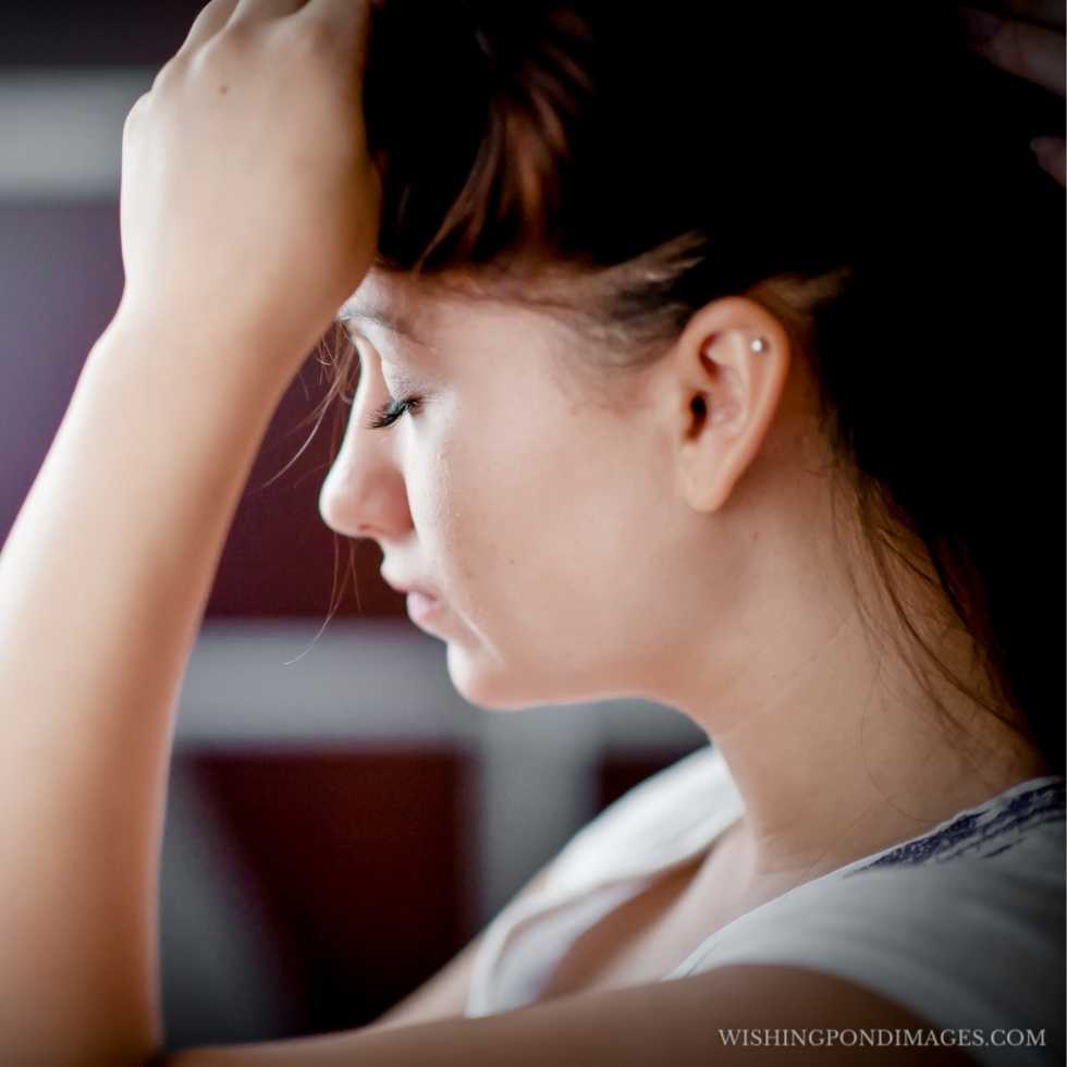 The sad face of a beautiful girl sitting in the room. Sad girl in the room