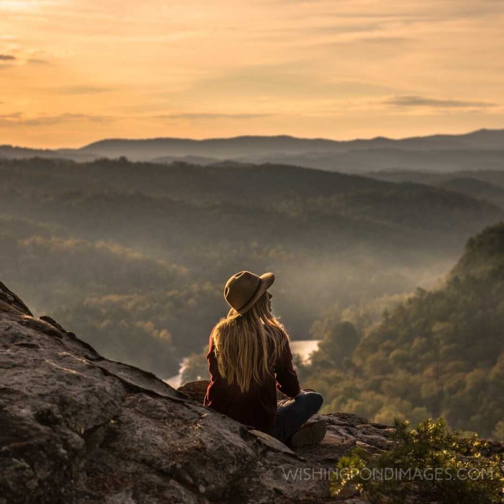 Woman sitting on Mountain Top at Sunset. Feeling alone images girl