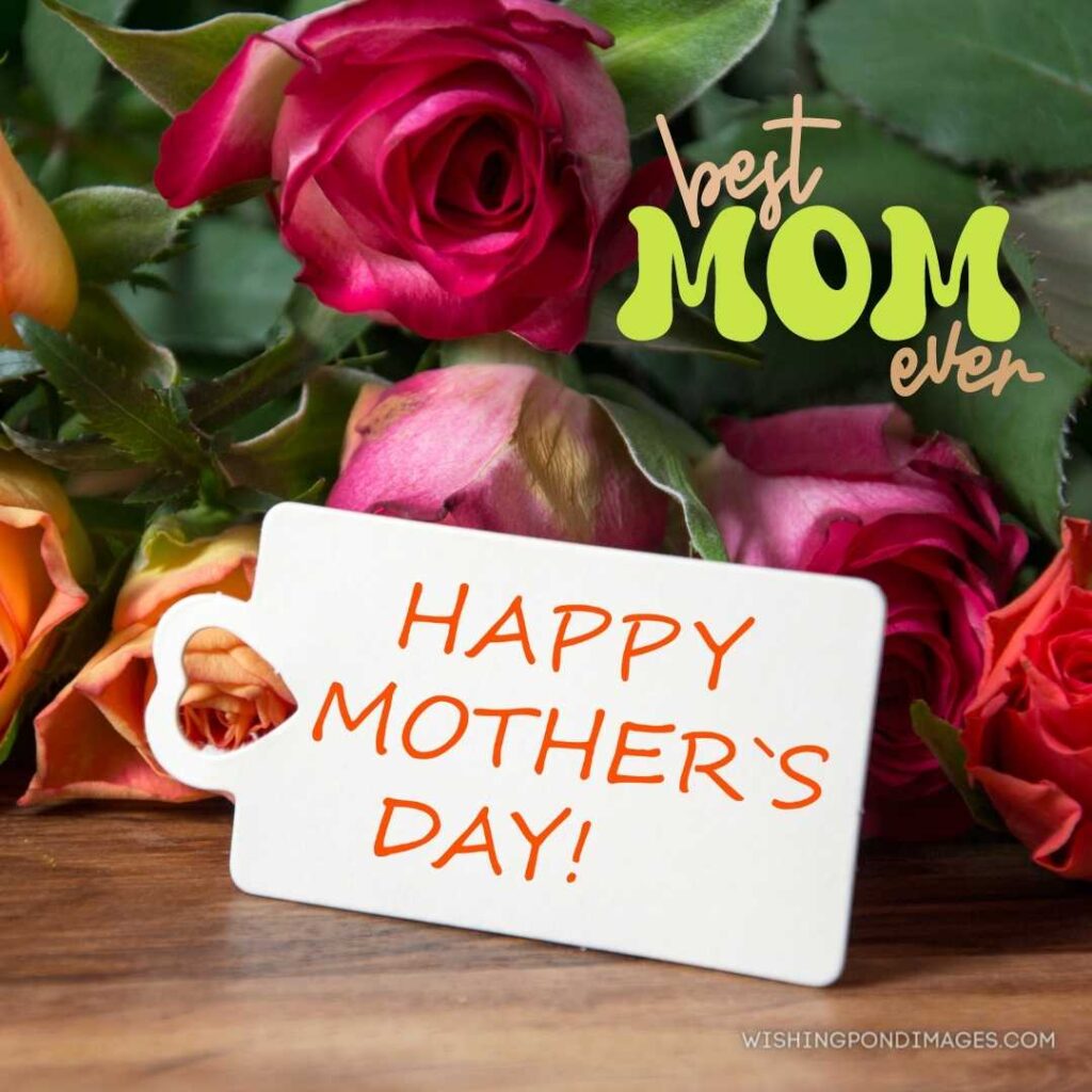 A happy mother's day tag on rose flowers background on wooden table. Happy Mothers Day images