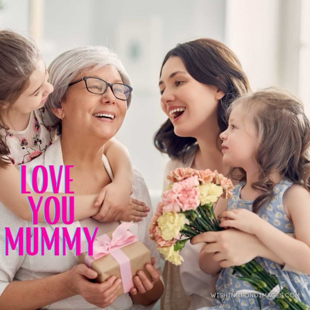 Children daughters are congratulating mom and grandmother offering them flowers. Happy Mothers Day images