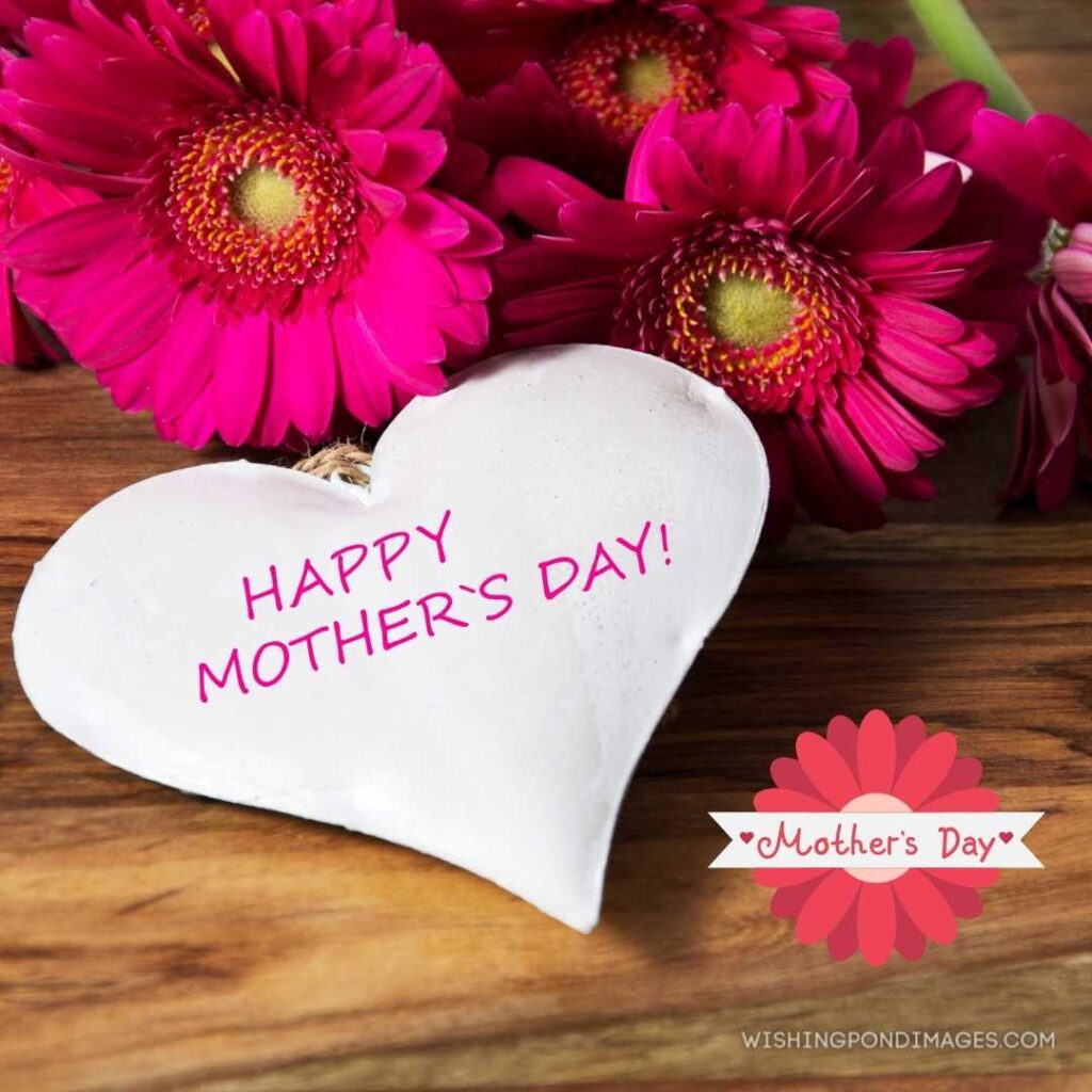 Happy mother's day card-shaped written on with pink flowers on brown-colored table. Happy Mothers Day images