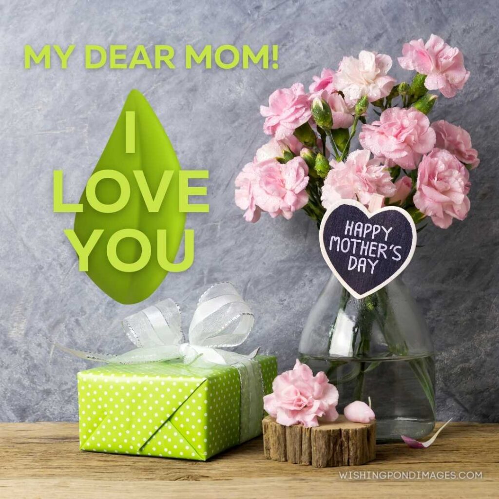 Pink carnation flowers in bottle with happy mothers day letter on heart wood and green gift box. Happy Mothers Day images