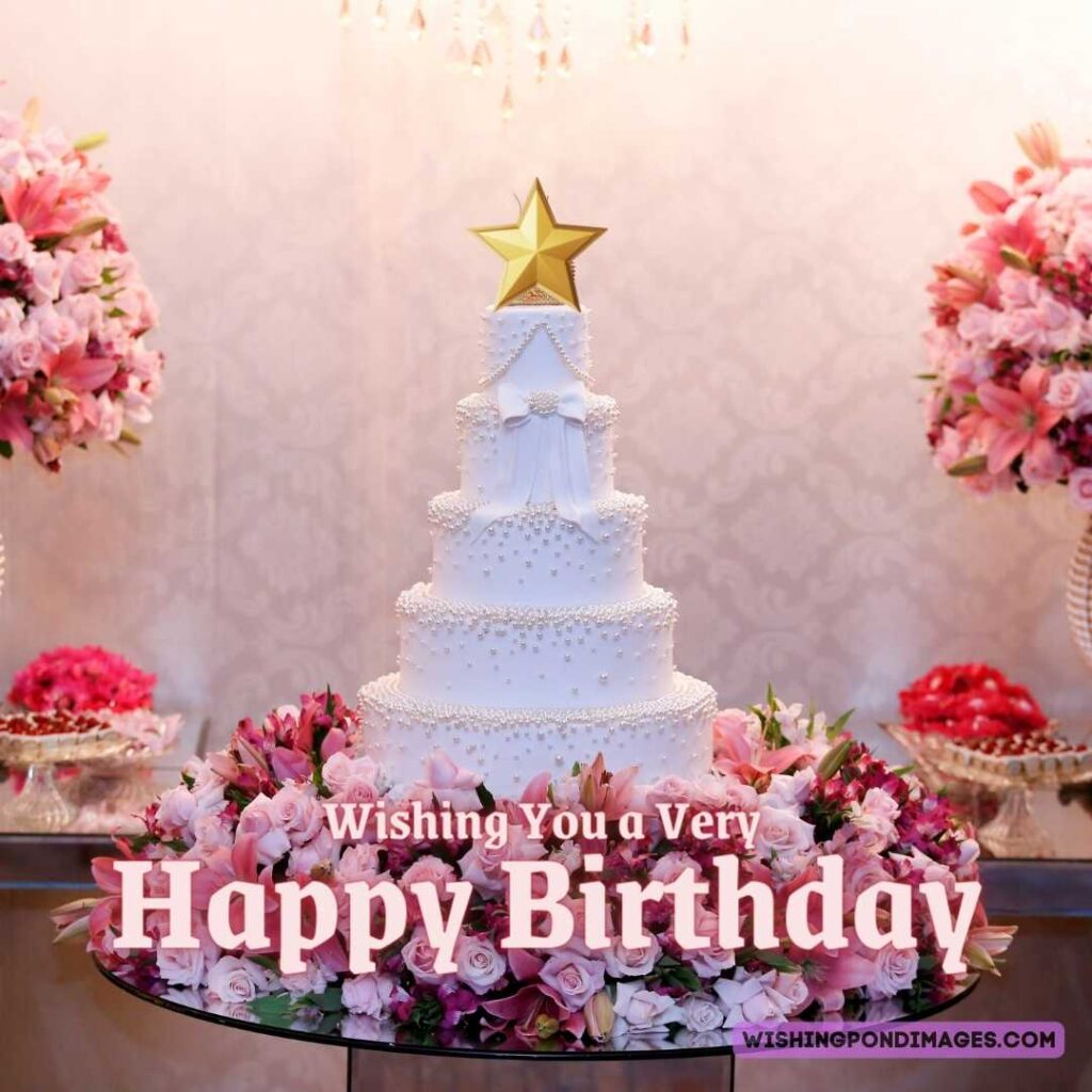 A beautiful five-layered cake with flowers at the bottom on the table. Happy birthday cake flowers images