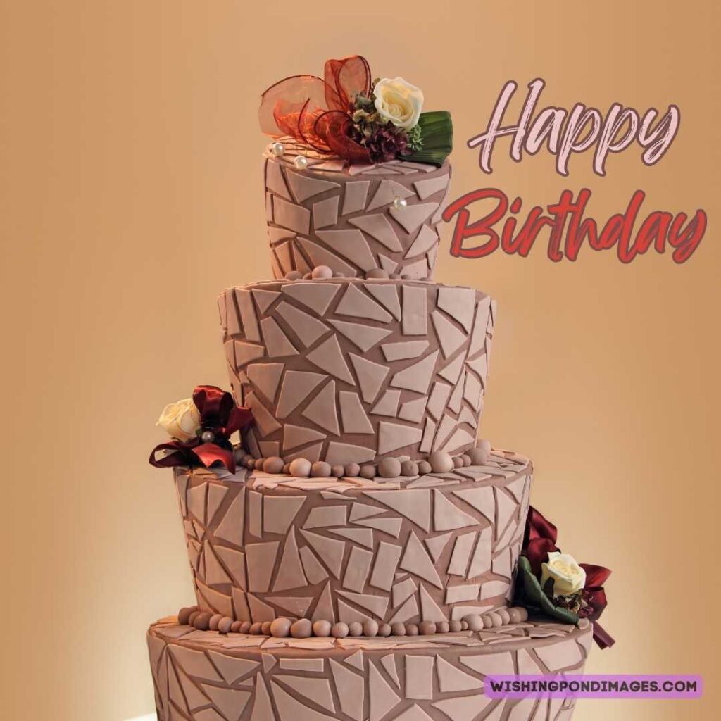 A beautiful four-layered brown color cake with flowers on light brown background. Happy birthday cake flowers images