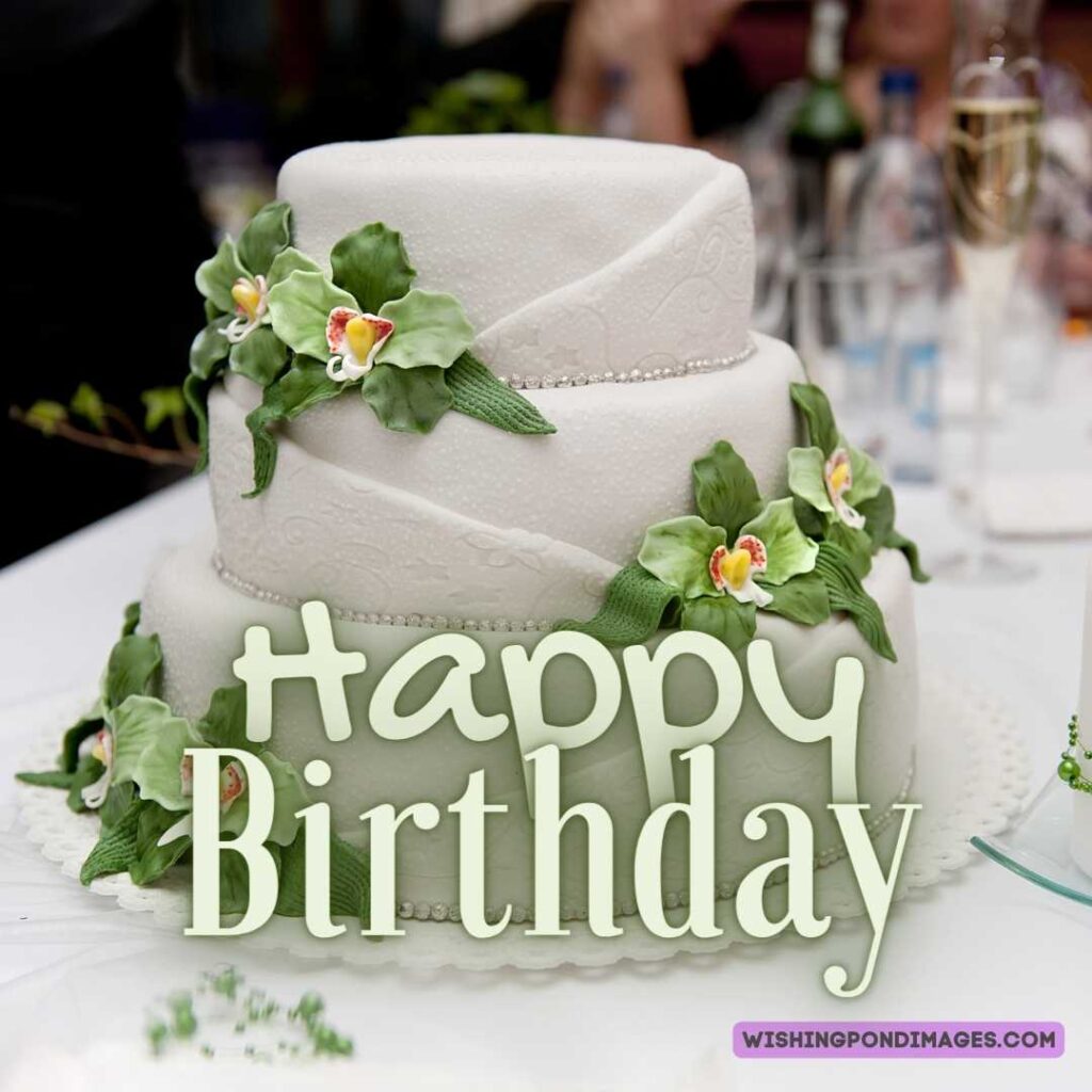 A beautiful three-layered birthday cake with green flowers. Happy birthday cake flowers images