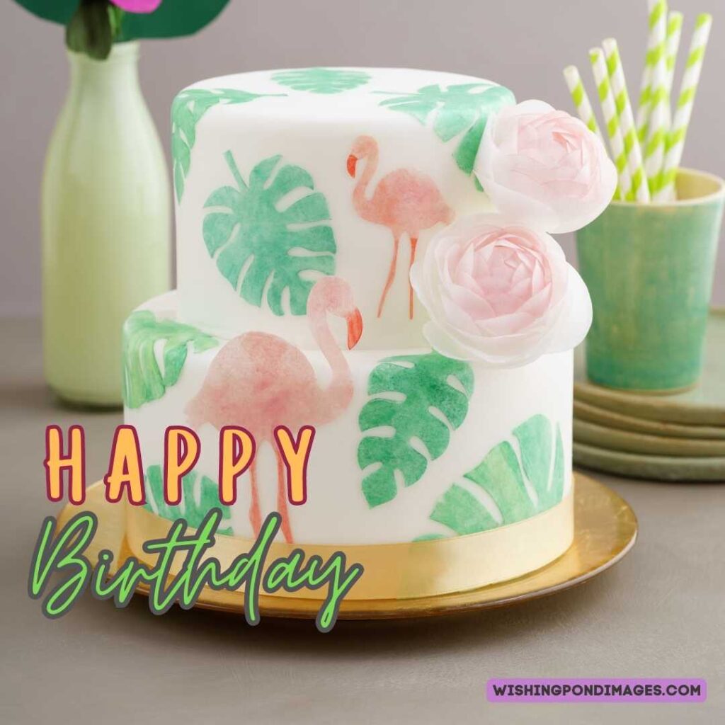 A two-layered cake with green leaves and flowers on the golden plate. Happy birthday cake flowers images