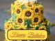 A two-layered sunflower flower cake sitting on the golden surface table. Happy birthday cake flowers images